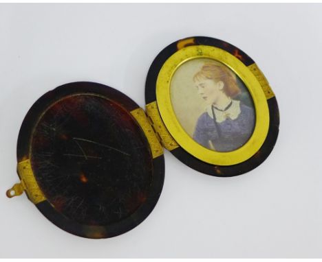 An oval tortoiseshell photograph frame containing a painted portrait miniature of a girl with red hair, frame 10cm long