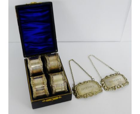 A set of four Epns napkin rings in a fitted box together with two Epns decanter labels to include Sherry and Whisky (a lot) 