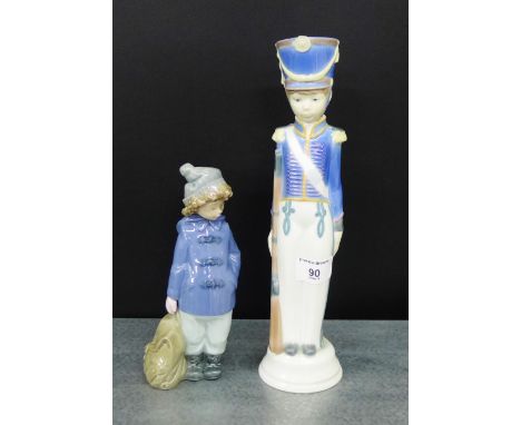 A Nao porcelain figure of a Boy in a Duffel Coat, together with a Lladro figure, tallest 29cm, (2) 