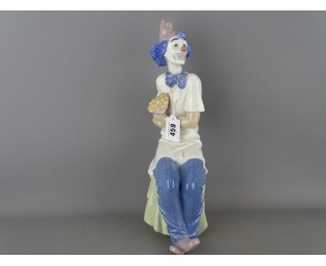 34 cms high Nao porcelain figurine of a seated clown holding a bunch of flowers