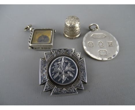 Hallmarked circular pendant and a silver compass fob, a sterling sewing thimble and a Victorian chased decorated brooch