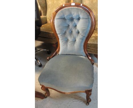 Victorian walnut button back fireside easy chair on cabriole legs and casters.