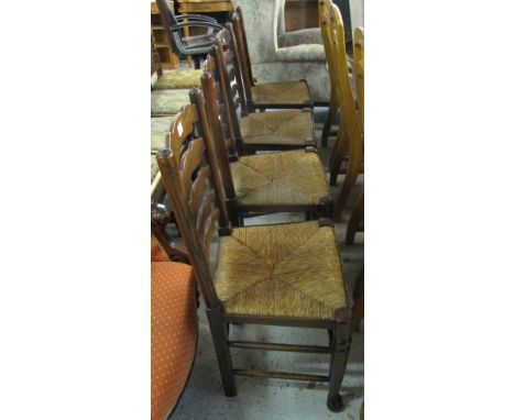 Set of four 20th Century elm ladder back kitchen chairs with rush seats. (4)