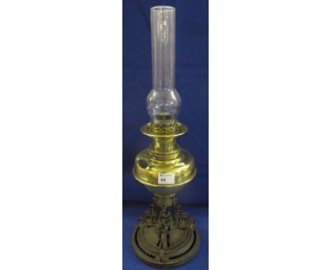 Early 20th Century oil lamp with brass reservoir and cast metal, scroll mounted foliate base, having clear chimney.