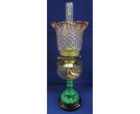 Early 20th Century brass double burner oil lamp with coloured and moulded glass reservoir on a foliate baluster stem with cer