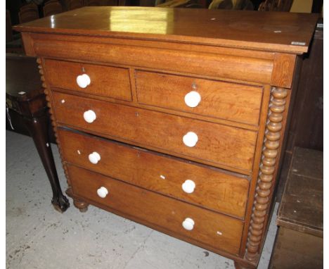 Victorian oak straight front chest of two short and three long drawers, with ceramic knob handles on bobbin turned supports.