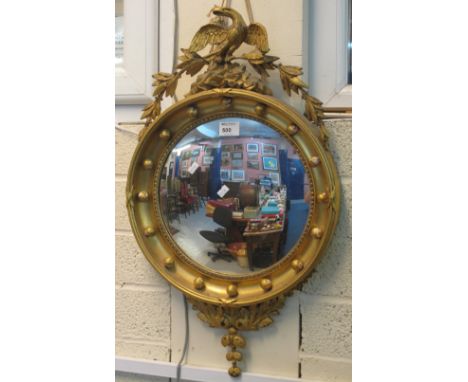 Gilt convex mirror decorated with relief foliate work and eagle pediment. CONDITION REPORT: Overall appears complete but gilt