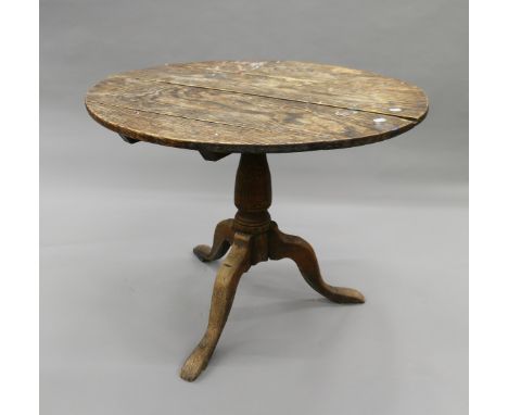 A George III oak tilt top tripod table. 90 cm diameter.