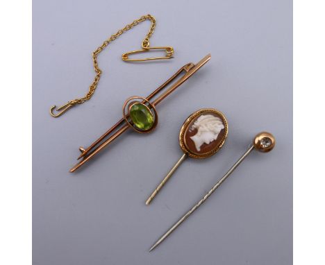 An unmarked gold bar brooch and two stick pins. 