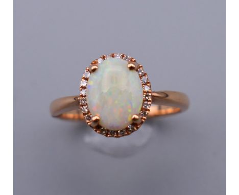 A 14 ct gold, opal and diamond ring. Ring size O. 