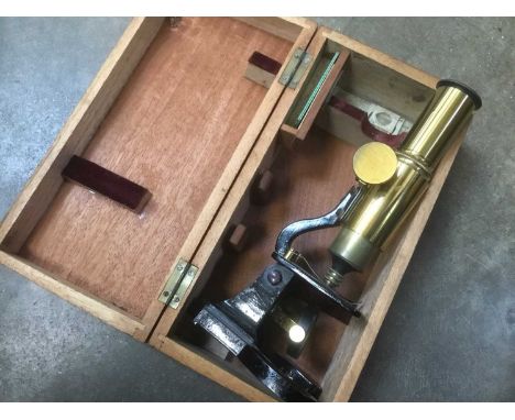 Student microscope, cased, with small group of slides