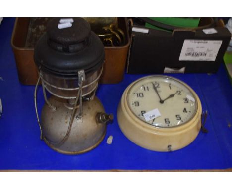 A Metamec plastic wall clock together withn a tilley lamp