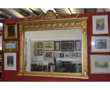 A giltwood overmantel mirror,  the frame with scrolling architectural crest, stepped pediment, carved frieze, rectangular bev
