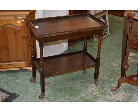 An oak tea trolley/card table, fold over top enclosing green baize playing surface.