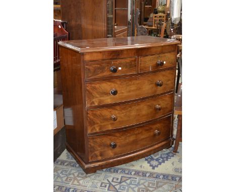 A Victorian bowfront mahogany chest, oversailing top, two short cockbeaded drawers over three graduated long, turned handles,