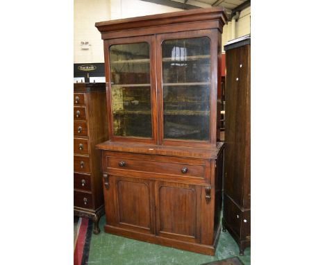 A Victorian mahogany secretaire bookcase, outswept cornice, two glazed doors enclosing velvet lined shelving, projecting base