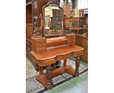 A Victorian duchess dressing table, shaped mirror, carved uprights, hinged covered compartment flanked by six drawers to supe