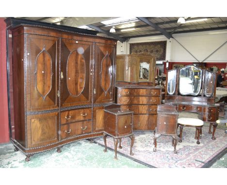 A mahogany bedroom suite comprising serpentine fronted triple wardrobe, garooned border to cornice, quarter veneered oval pan