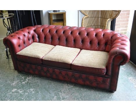 A red leather Chesterfield sofa.