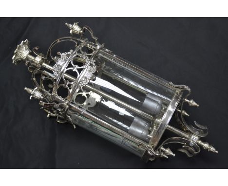 A cylindrical chromed wrought metal four light ceiling lamp.
