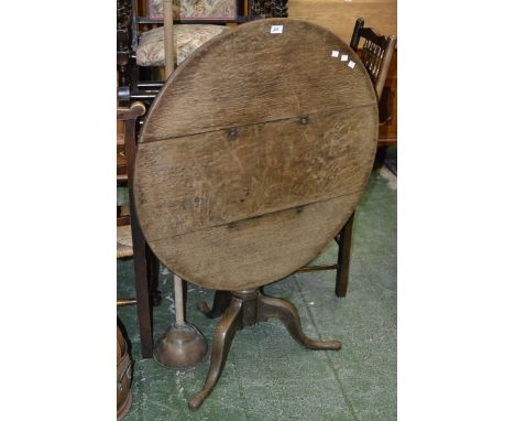 A George III oak tilt top table with tripod base