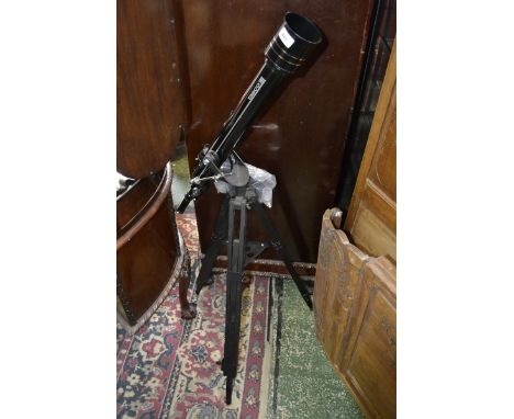 A Tasco 60mm refractor telescope on tripod with eyepieces.