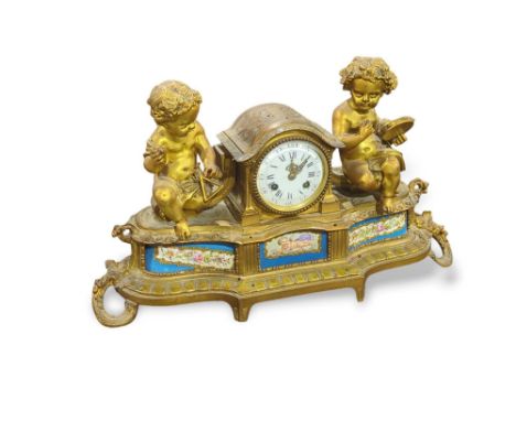 A French ormolu mantel clock, with painted ceramic panels in the Sevres style the clock face flanked by two putti playing ins