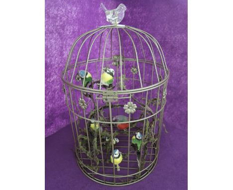 A vintage bird cage, containing a display od decorative birds