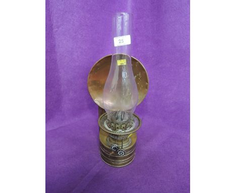 A vintage wall mounted oil burner with brass and copper body