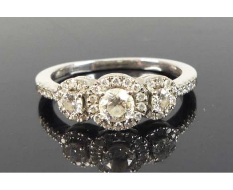 An 18ct white gold diamond triple cluster ring, featuring three graduated round brilliant cut diamonds within a halo of 30 me