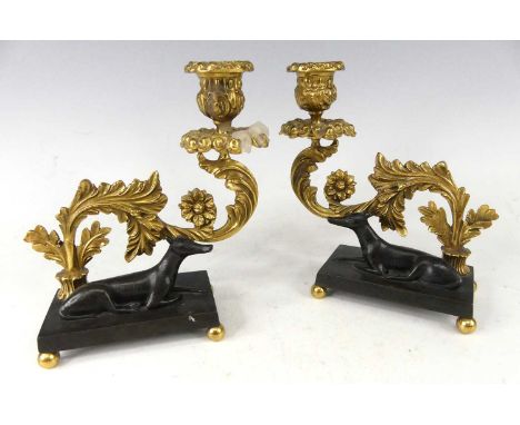 A pair of Regency bronze and gilt bronze candelsticks, each of heavy scroll acanthus leaf form and raised on integral bases m