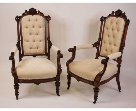 A pair of Victorian walnut and later re-upholstered parlour chairs, each having carved and swept frames, raised on ring turne