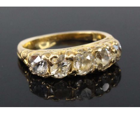 A yellow metal late Victorian diamond half hoop eternity ring, comprising five graduated old cushion cut diamonds in carved c