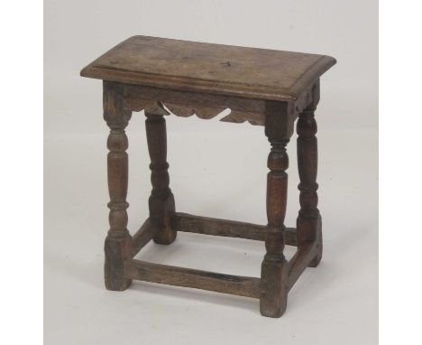A circa 1700 oak joint stool, the top having a moulded edge above a carved frieze, all on turned and square cut supports unit