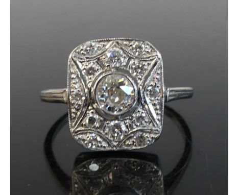 A white metal Art Deco diamond panel ring featuring a centre old European cut diamond in a bezel setting within a panel of 12