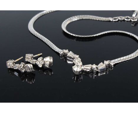 A white metal diamond necklet and earring set, the necklet comprising a round brilliant cut diamond suspended below four smal