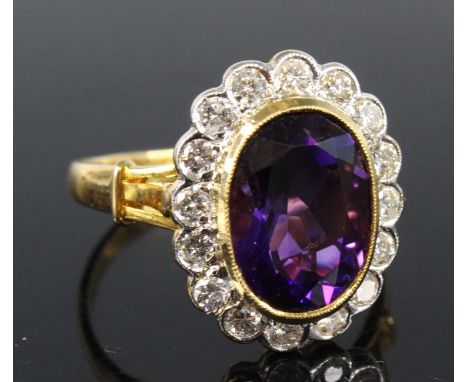 An 18ct yellow gold, amethyst and diamond oval cluster ring, featuring a centre oval amethyst within a border of 16 round bri