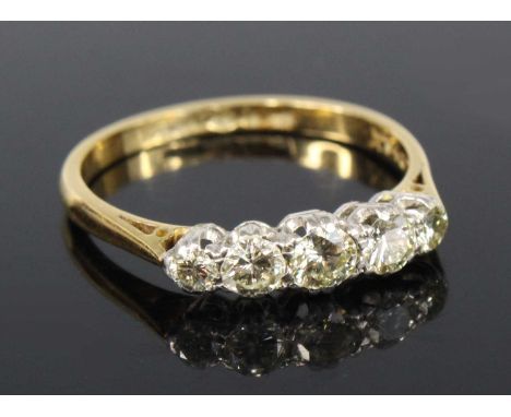 A yellow and white metal diamond half hoop eternity ring, comprising five graduated round brilliant cut diamonds in claw sett