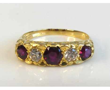 A yellow metal ruby and diamond half hoop eternity ring featuring 3 graduated round rubies alternating with 2 transitional br