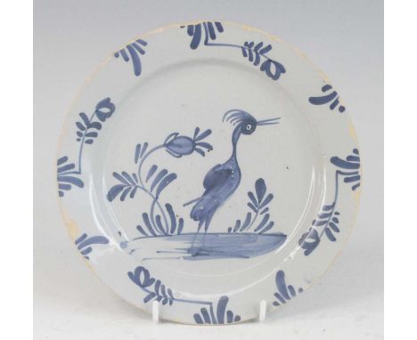 A Lambeth or Bristol Delftware plate, mid 18th century, decorated with a heron amongst foliage, dia.22.5cm