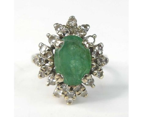 A white metal, emerald and diamond oval cluster ring, comprising a centre oval emerald within a border of 28 single cut diamo