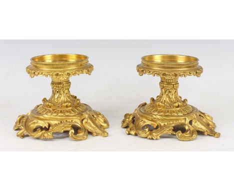 A pair of Rococo Revival gilt bronze dwarf torchere stands, each having waisted acanthus leaf cast columns and on swept bases