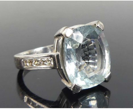 An 18ct white gold, aquamarine and diamond dress ring, comprising an oblong aquamarine in a four claw setting, with five Prin