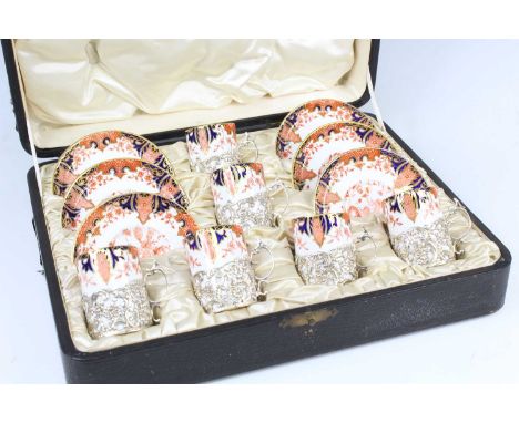 A cased set of six Edwardian Royal Crown derby coffee cans and saucers, each decorated in the Imari palette and with puce mar