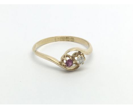 A Vintage gold ring with a two stone crossover a ruby and diamond. ring size R-S