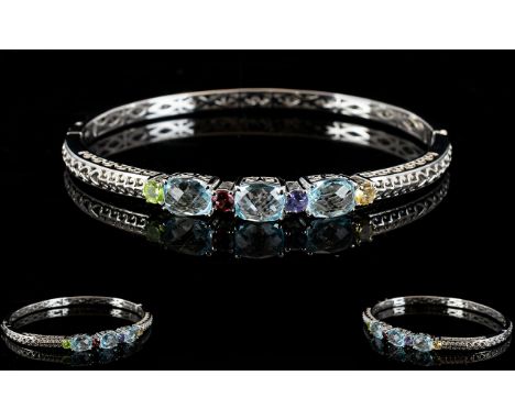 Sky Blue Topaz and Multi Gem Bangle, three oval cut sky blue topaz with chequerboard faceting to the surface, interspaced wit