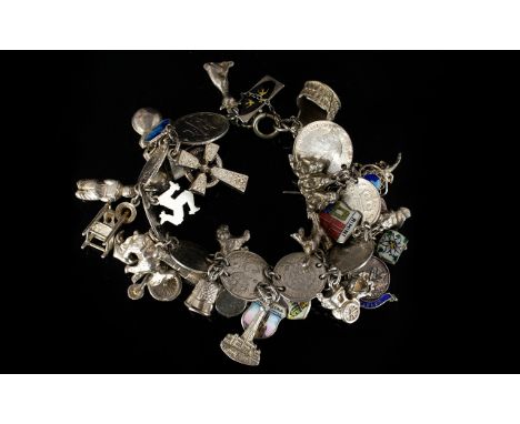 A Silver Charm Bracelet Loaded With Charms Approx 30 charms to include thimble, coins, flags, enamel map etc. Total weight, 6