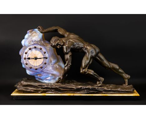 Art Deco Figural Clock Large spelter clock in the form of a male gymnast pushing a rock fashioned in opalescent glass, raised