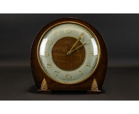 A Mid 20th Century Mantel Clock Of typical form in curved wood case with gold tone filigree decoration. Silvered dial with go