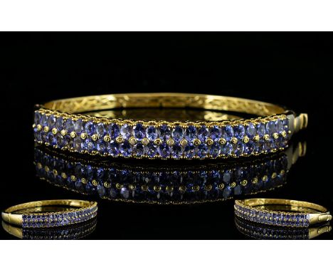 Tanzanite Double Row Hinged Bangle, two rows of oval cut tanzanites, totalling 9cts, set vertically across the front of the b